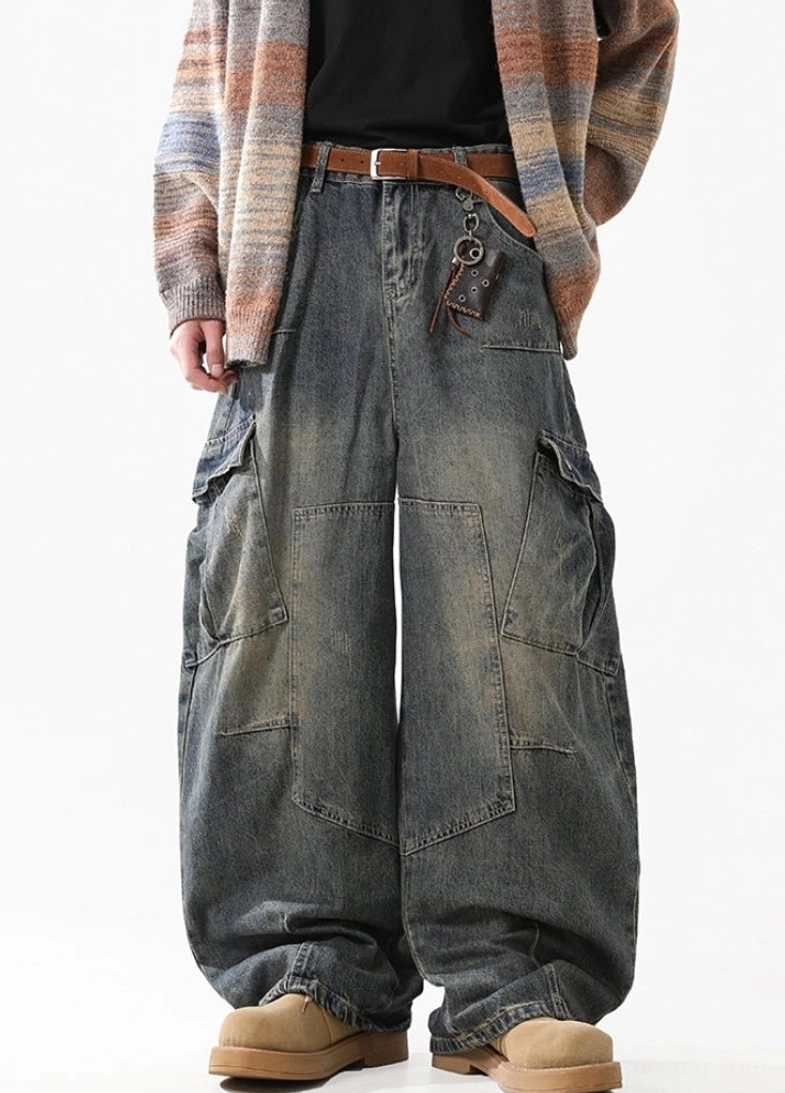 Full front view of relaxed wide-leg vintage cargo jeans featuring a distressed faded blue wash and clean oversized pocket layout