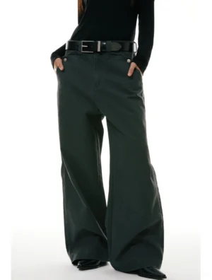 Low-angle front view of relaxed wide-leg workwear denim jeans styled with a high waist and front pockets in a minimalist white studio