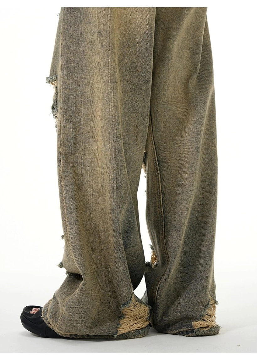 Close-up of raw frayed hems and faded retro blue wide-leg denim on distressed ripped jeans