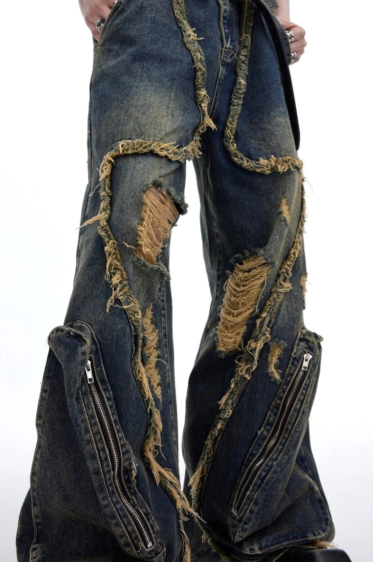 Close up of retro deconstructed ripped denim jeans with heavy frayed seamwork, layered distressing and zippered side cargo pocket