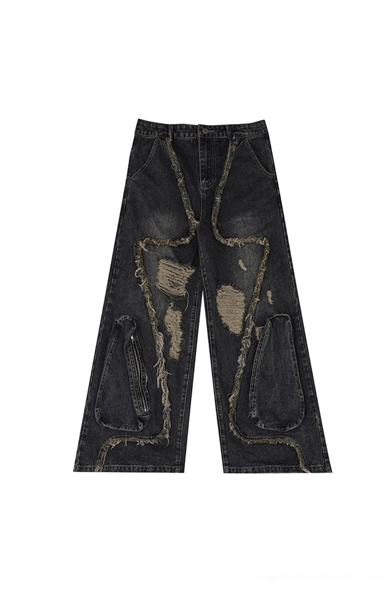 Flat lay of washed black deconstructed wide leg ripped jeans with raw frayed seams, distressed patches and zipper side pockets