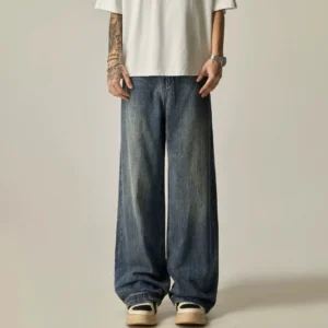 Model wearing washed blue ultra-wide leg denim jeans with a white t-shirt and platform sneakers in a streetwear outfit