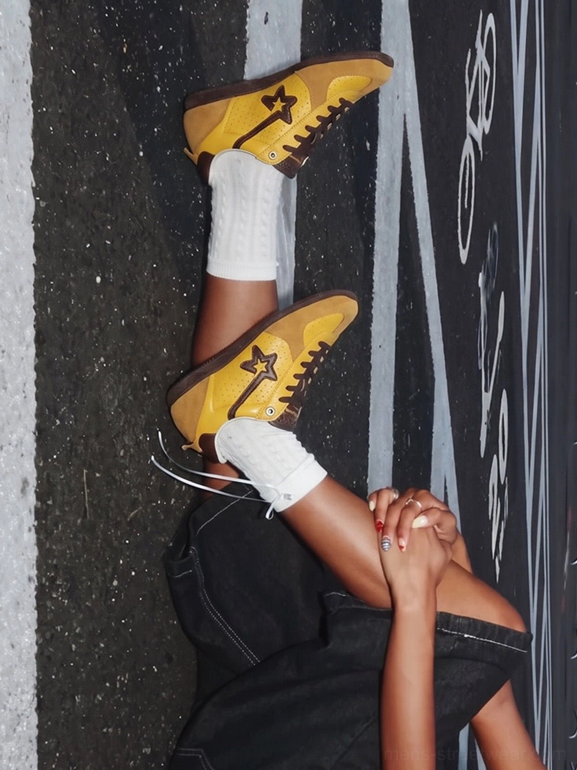 Yellow brown retro low-top suede streetwear trainers paired with white crew socks in an overhead urban fashion view