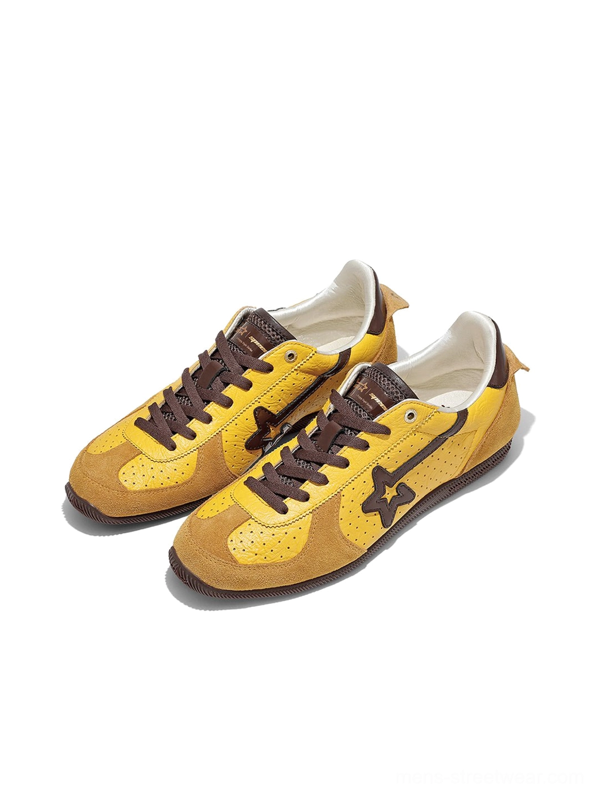 Pair of yellow brown low-profile suede streetwear trainers with star side branding, brown laces, and contrast trim
