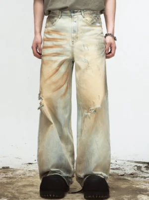 Front view of retro sun-faded yellow ripped wide-leg denim jeans on male model in a studio