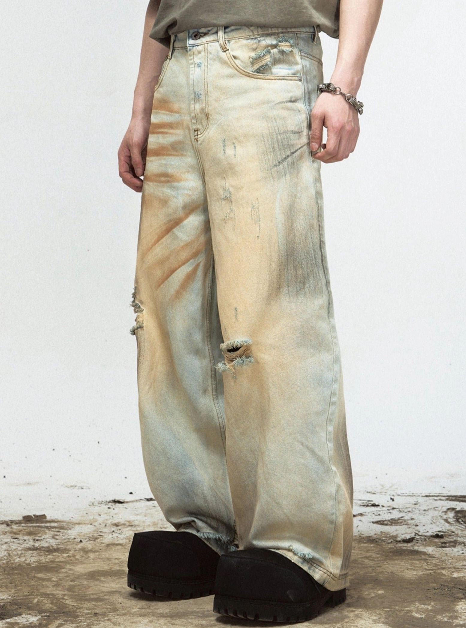 Side view of vintage yellow washed distressed wide-leg denim jeans with ripped knee detail
