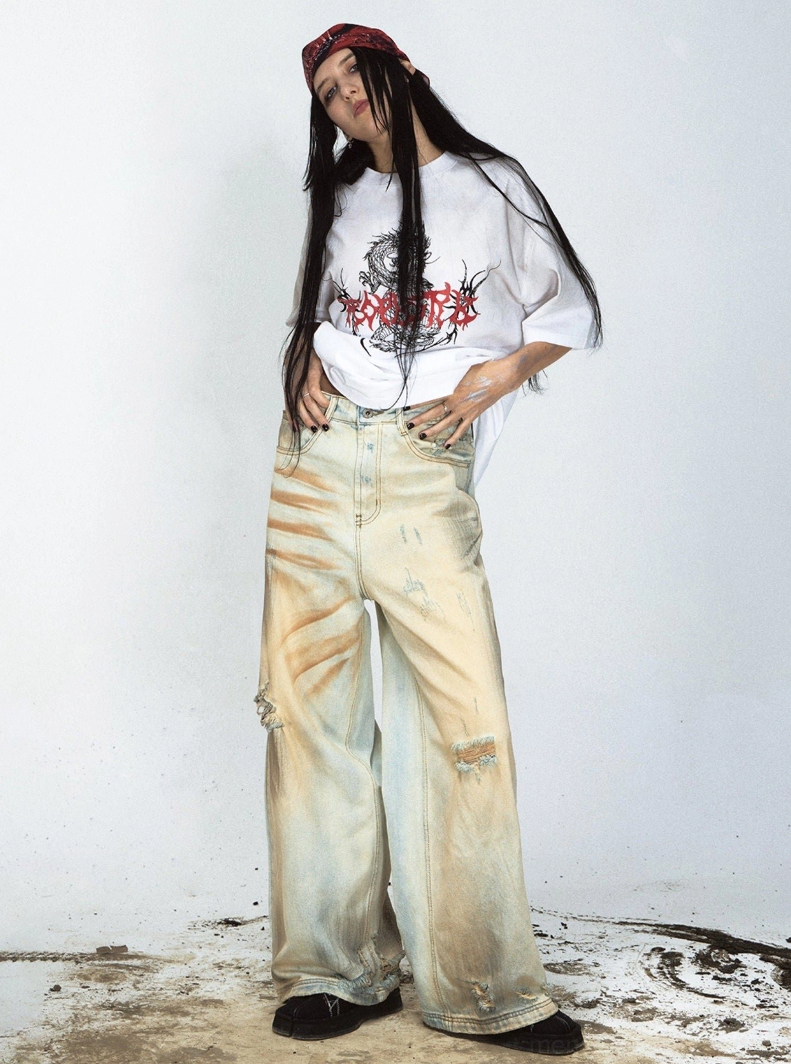 Female model front view in retro yellow faded ripped denim jeans with red bandana streetwear styling