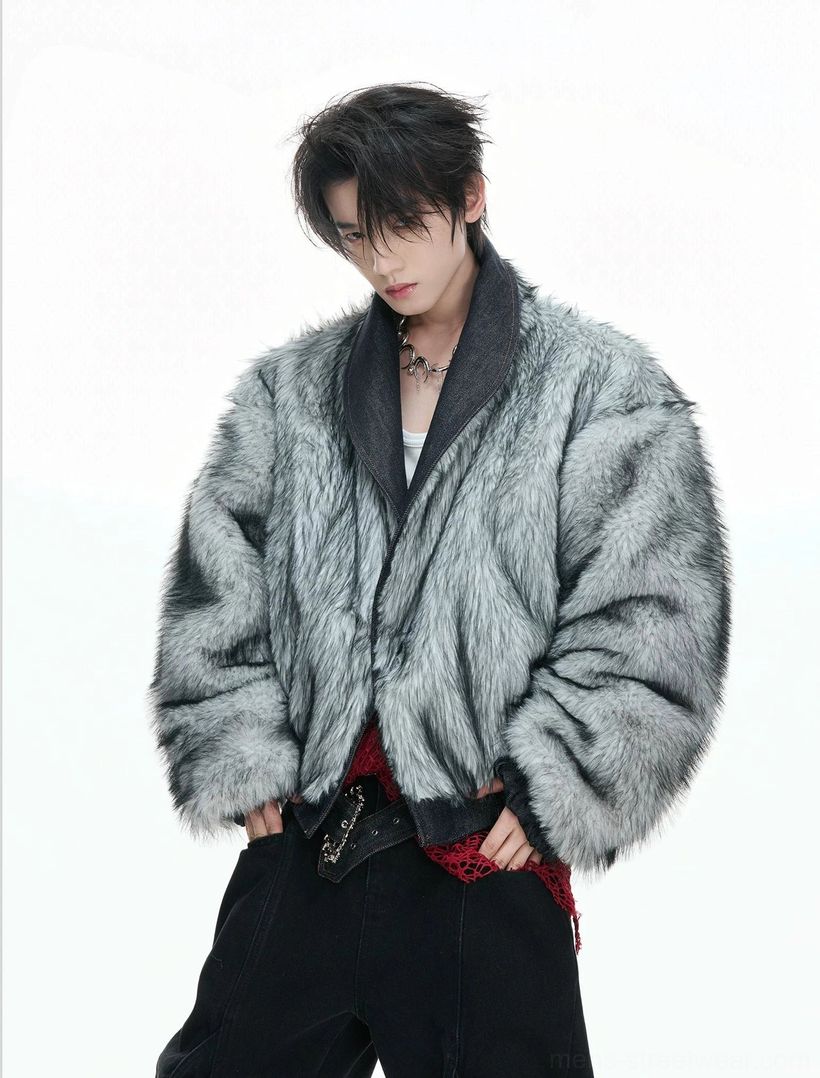 Male model wearing the faux fur outer side of reversible grey and indigo denim bomber jacket with button front and red mesh waist detail