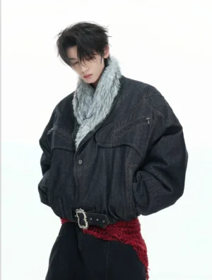 Male model wearing reversible dark indigo denim bomber jacket with oversized grey faux fur shawl collar, zip chest pockets and silver belted waist front view