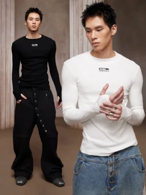 Two male models wearing black and white ribbed compression long sleeve tees in a vintage columned interior, showcasing slim Korean streetwear styling and fitted stretch silhouettes