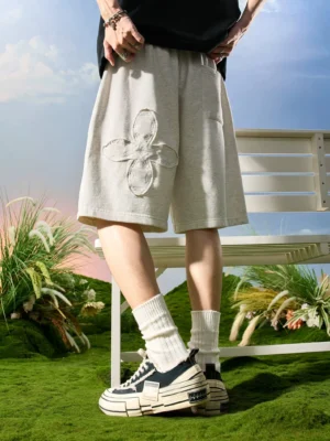 Rice gray relaxed drawstring sweat shorts with tonal floral appliqué shown from the front in a Korean streetwear outfit