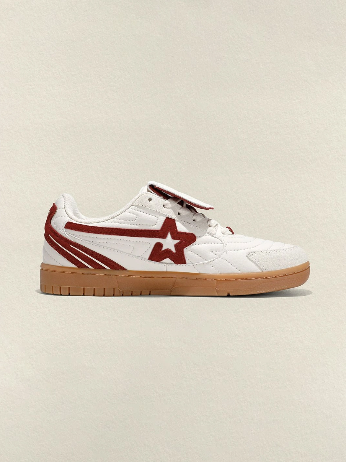 Front-side product view of rice red retro court sneakers with wine-red suede star logo, stripe detail and rounded toe