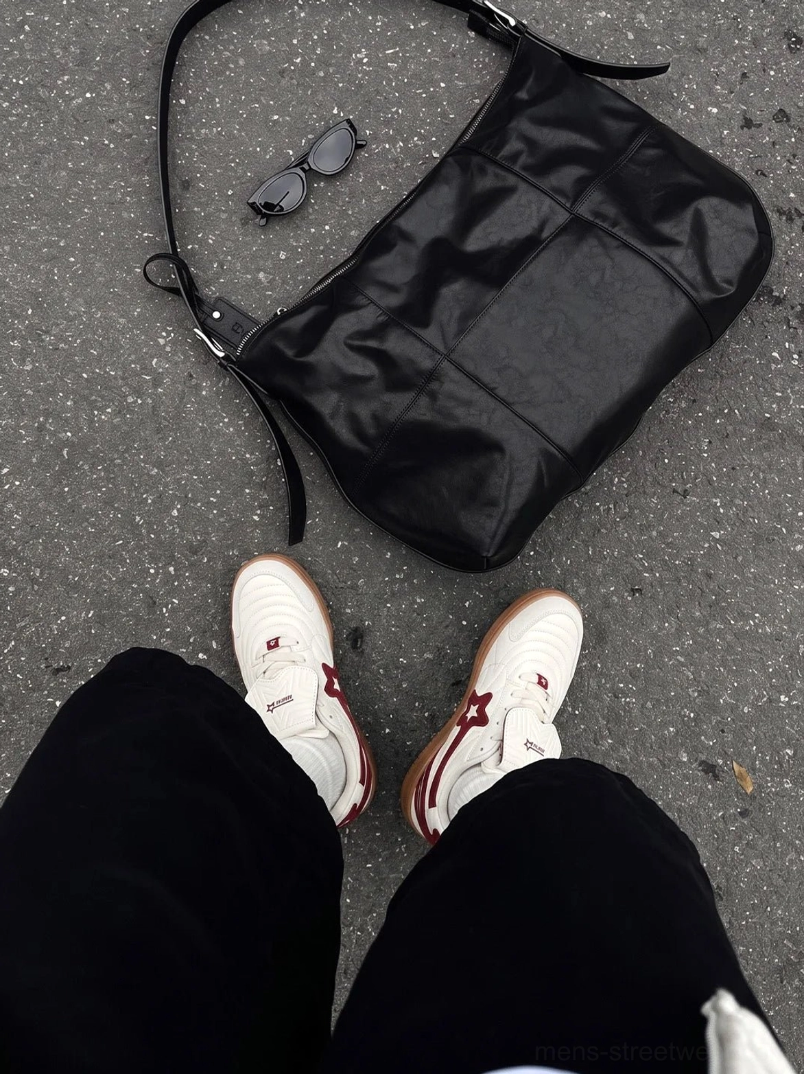 Top-down on-foot view of rice red star panel retro court sneakers with black pants on asphalt street