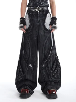 Front view of washed black cyberpunk wide-leg denim jeans with grey contrast panels, riveted thigh pockets, and an ultra-baggy streetwear silhouette