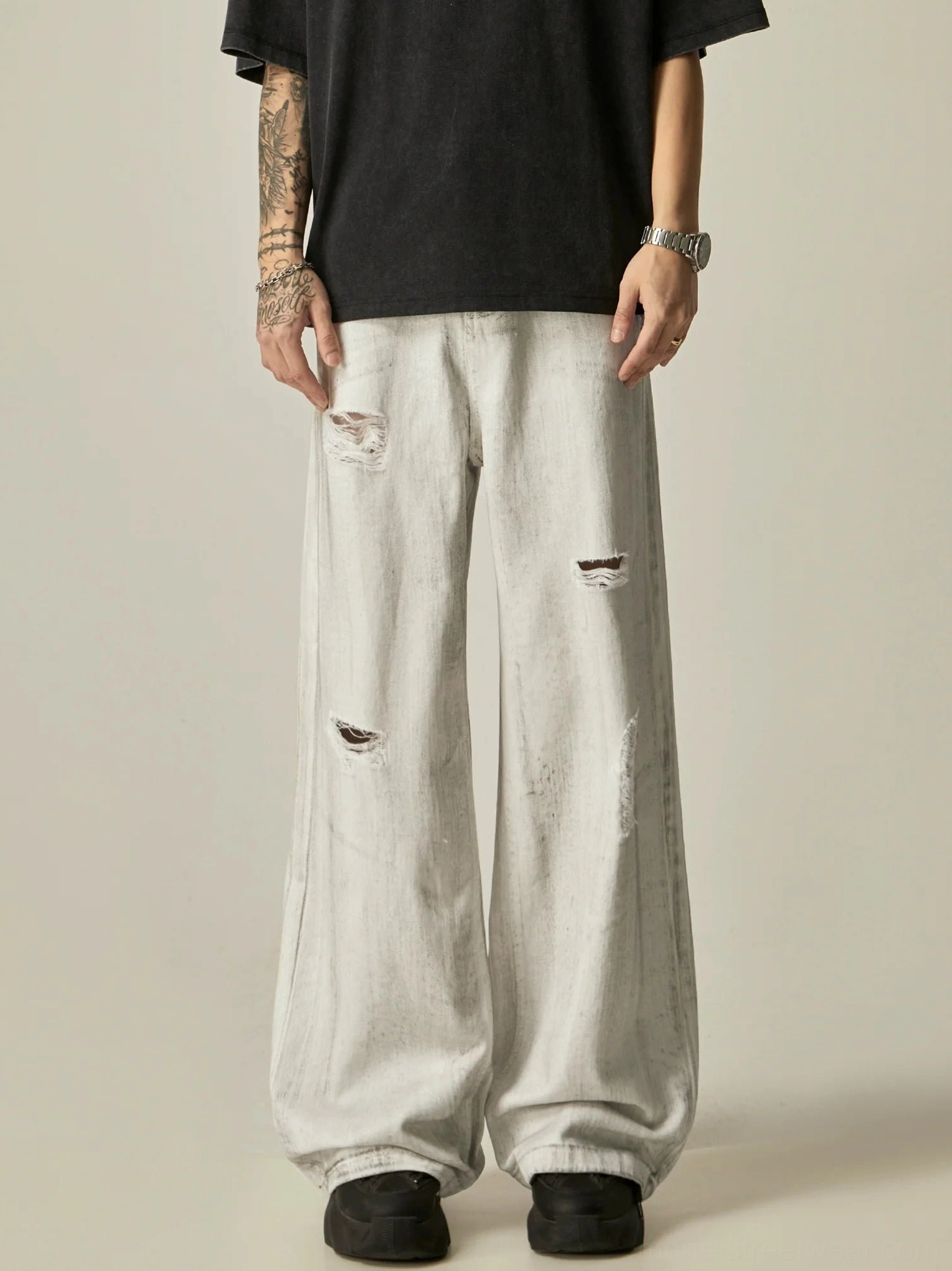 Full-body front styling view of ripped off-white acid wash wide-leg denim jeans