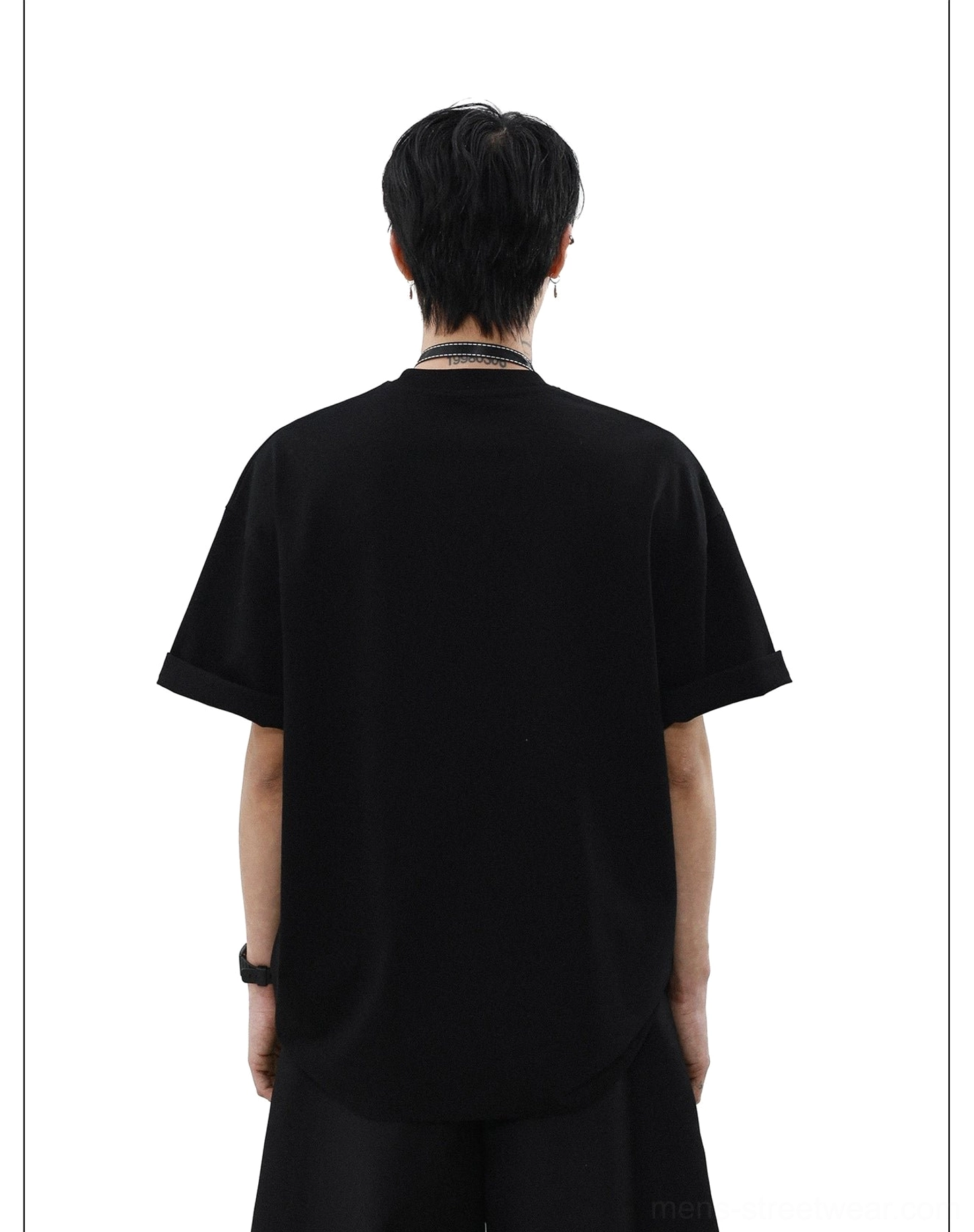 Back view of solid black oversized crewneck T-shirt with rolled short sleeves and relaxed streetwear fit