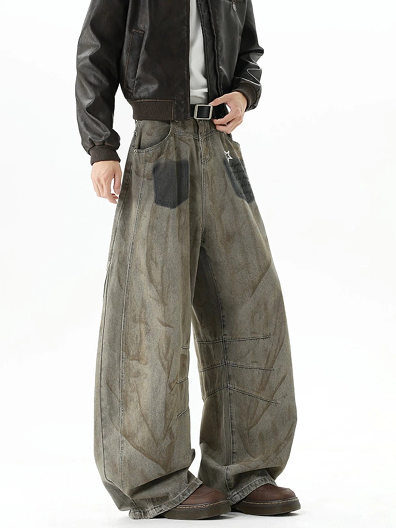 Left front three-quarter view of oversized vintage balloon jeans with black front patch pockets, lower-thigh seam details, and dusty brown wash