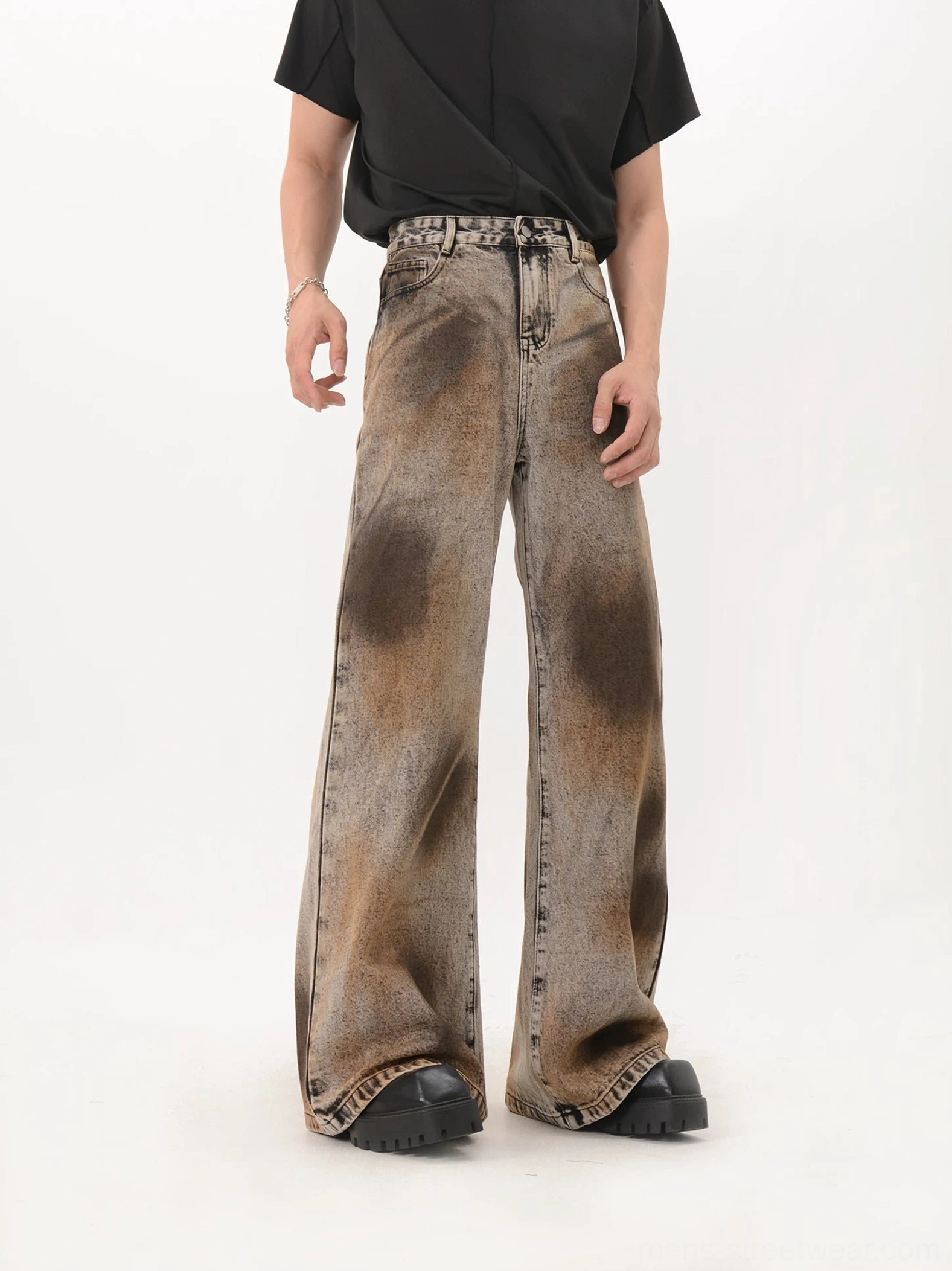 Relaxed front view of high waisted black flare jeans featuring circular rust brown eclipse fading and wide streetwear silhouette