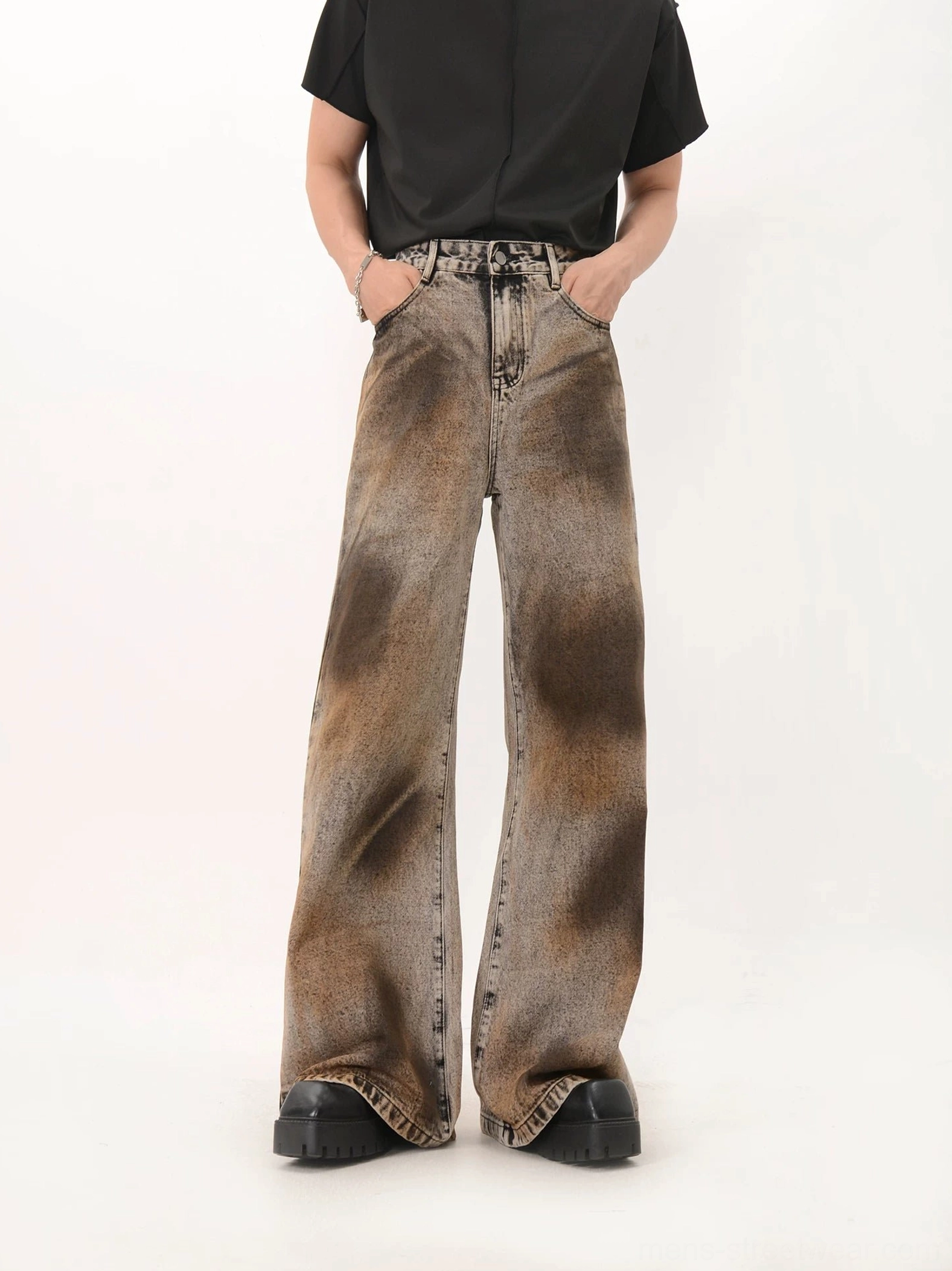 Front view of oversized black tie dye wash wide leg denim jeans with rust brown faded thigh detailing and floor length fit