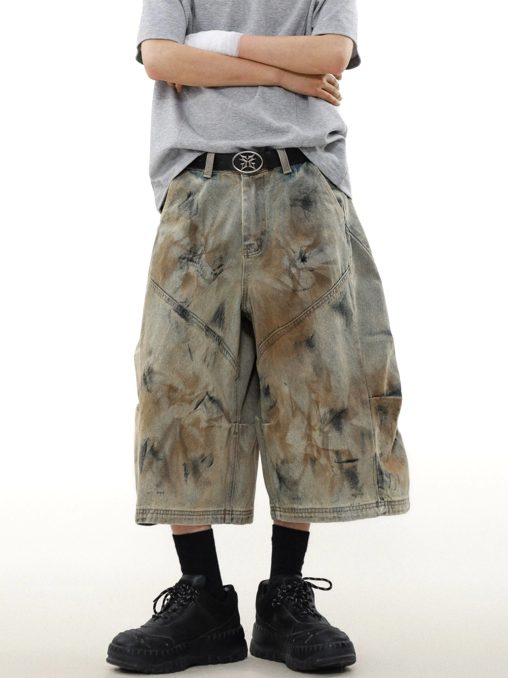 Close front view of oversized cargo denim shorts featuring curved panel seams heavyweight fabric and art dyed texture