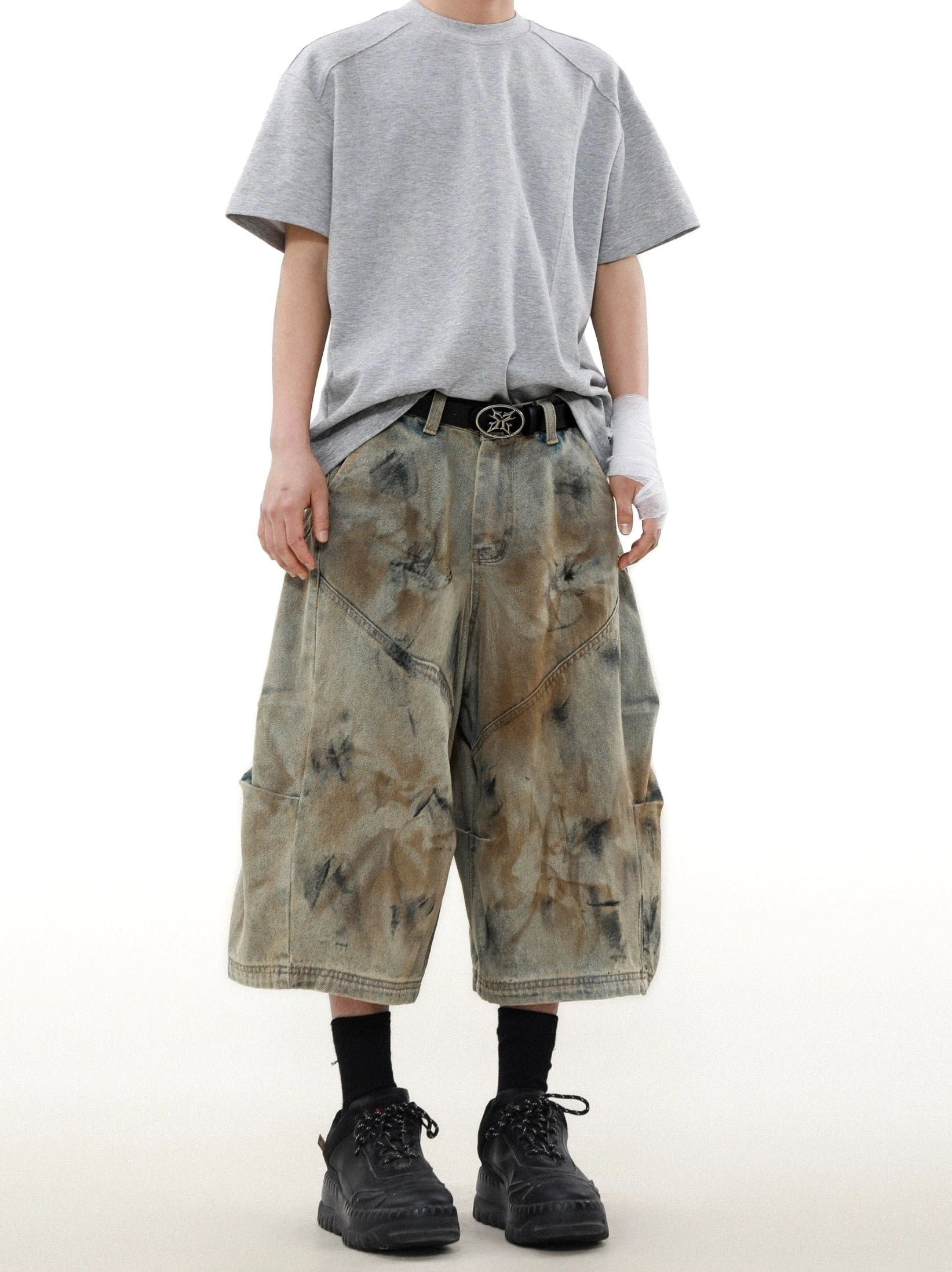 Side view of cropped mid-calf cargo denim shorts showing utility pockets wide legs and distressed storm dye texture