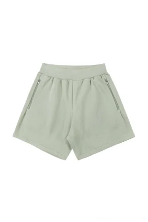 Sage green relaxed unisex sweat shorts with elastic ribbed waistband, secure side zipper pockets, and casual Seoul streetwear silhouette