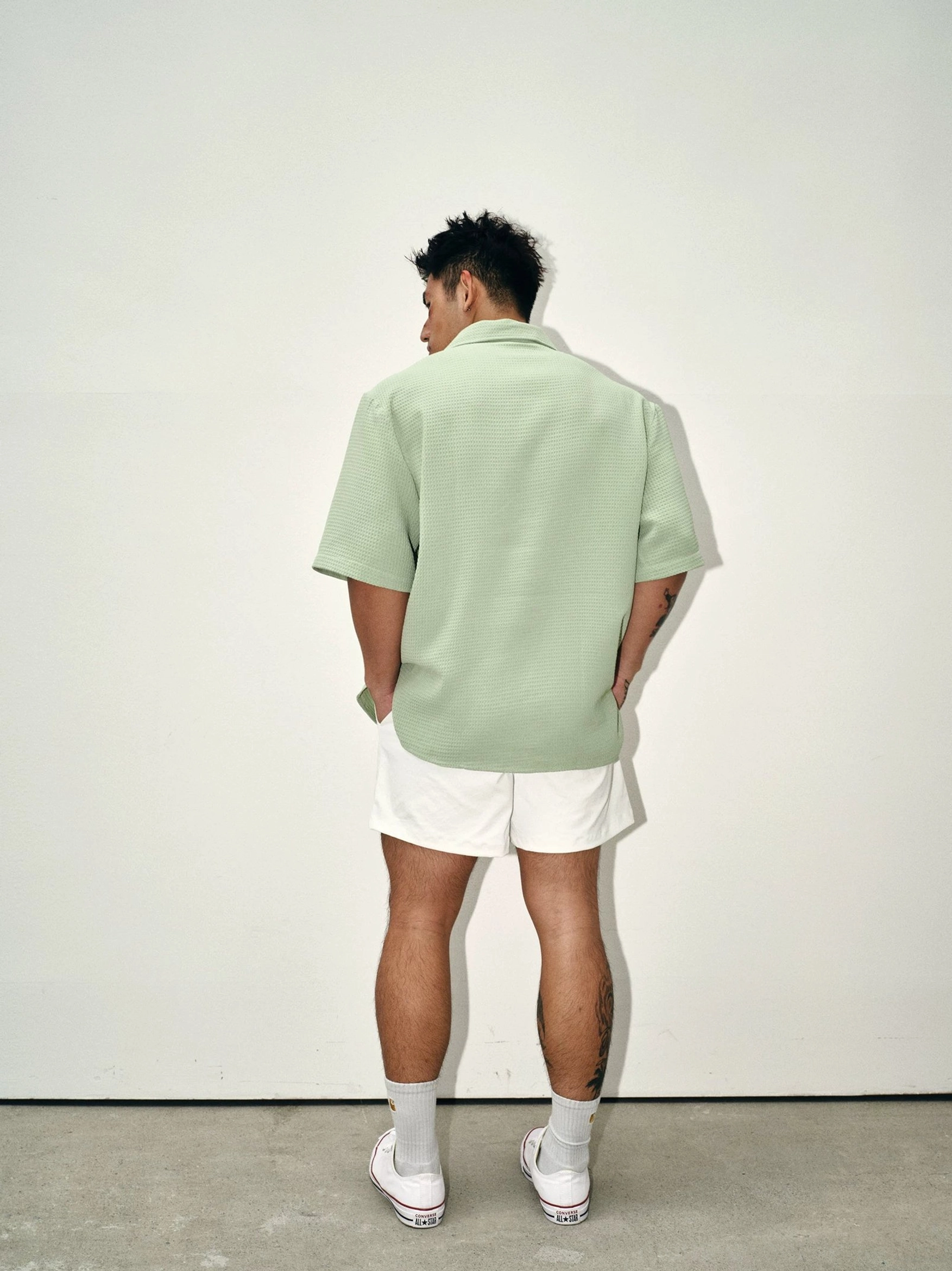 Back view of mens sage green waffle camp collar shirt showing clean solid-color rear panel and relaxed short sleeve fit