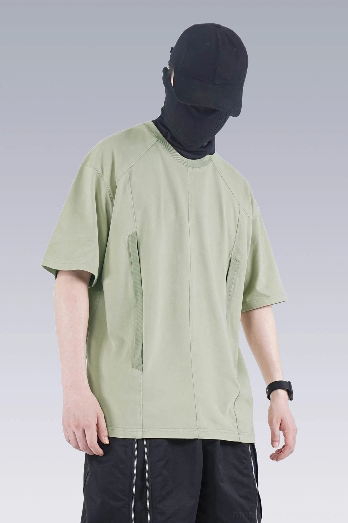 Front view of sage green washed technical oversized T-shirt with front seam tailoring, hidden pocket, and loose fit