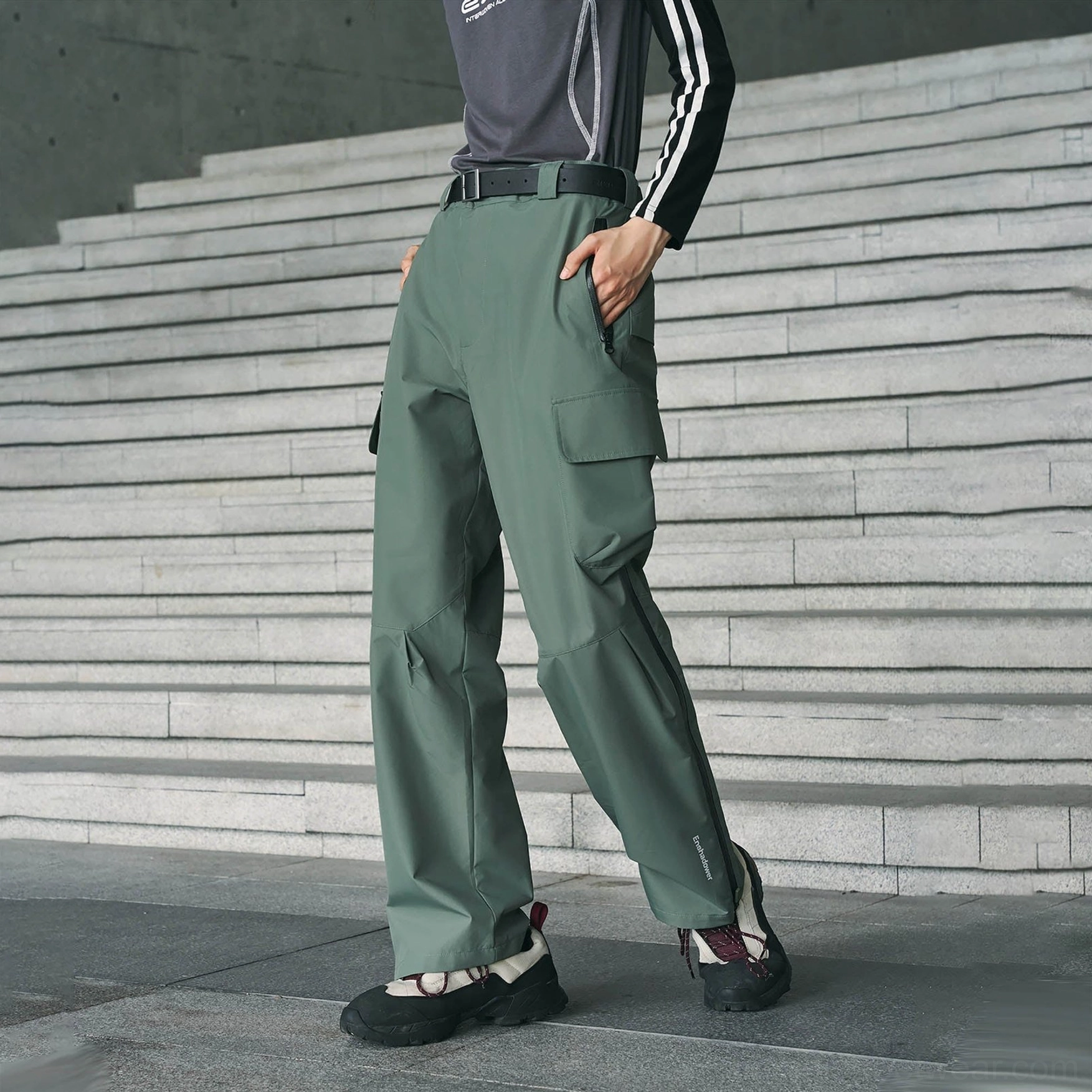Sage green waterproof cargo pants shown from the side and rear with multifunctional cargo pockets and ankle zipper detail