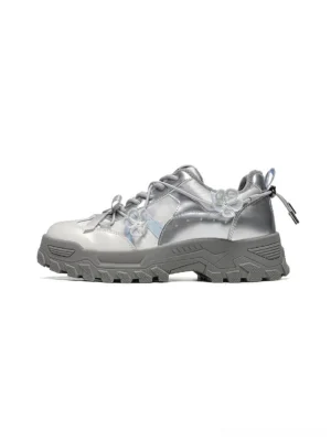 Silver Sakura plush chunky trail sneaker in a three-quarter side view with metallic layered upper, floral ribbon accents, heel pull tab, and rugged lug outsole