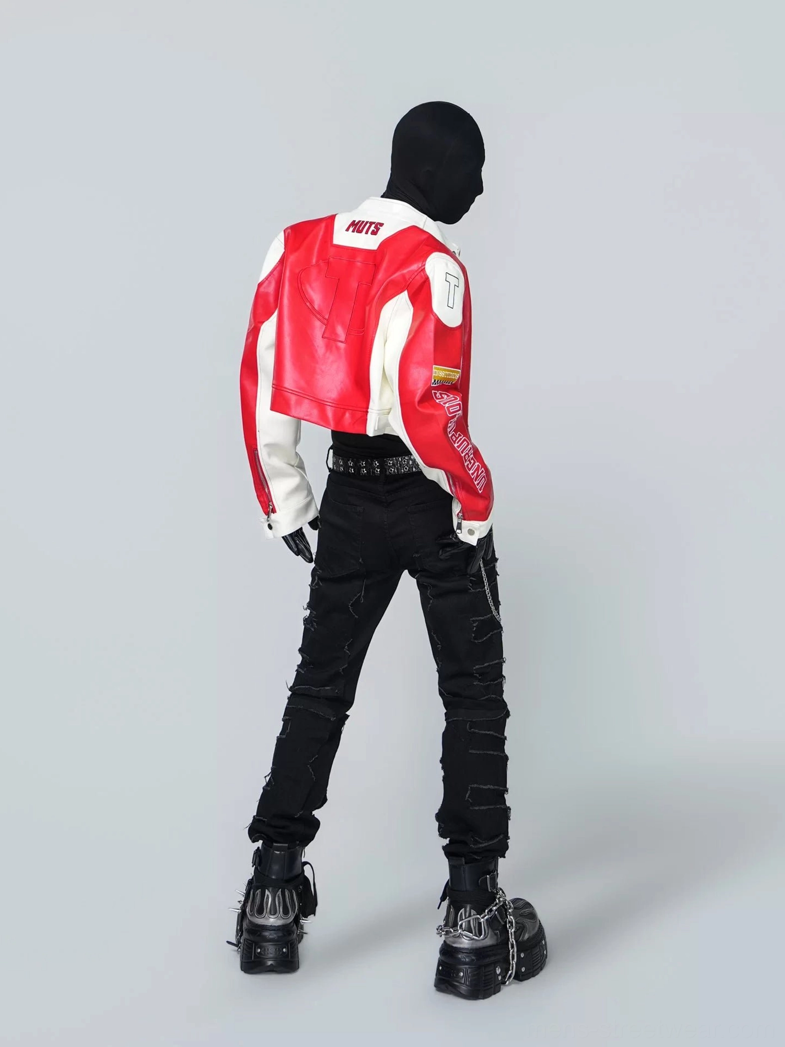 Back view of a scarlet cropped racing jacket with contrasting white sleeves, streamlined PU leather panels, MUTS collar lettering, black ripped jeans, and platform combat boots