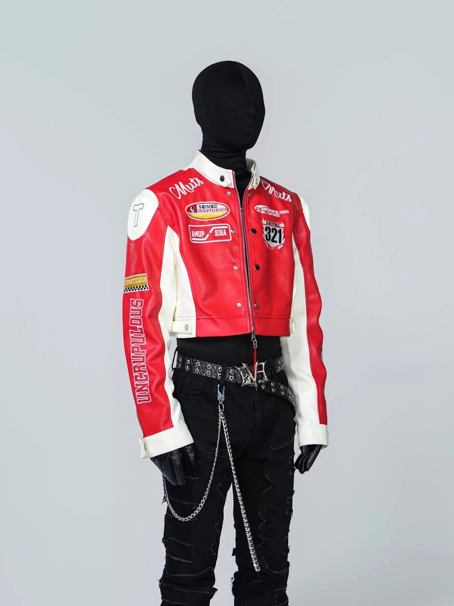 Front view of a scarlet red and white cropped racing jacket with PU leather texture, motorsport patches, racing graphics, black ripped jeans, chain accessories, and chunky streetwear boots