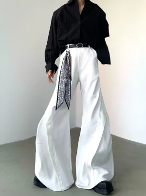 Close-up view of white Korean streetwear wide-leg flare trousers with dramatic twisted leg seams and high-rise waist