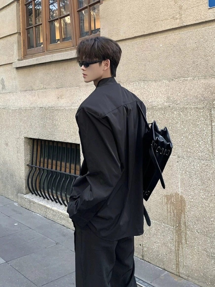 Black oversized stand collar shirt rear side view with relaxed silhouette and monochrome Korean streetwear styling