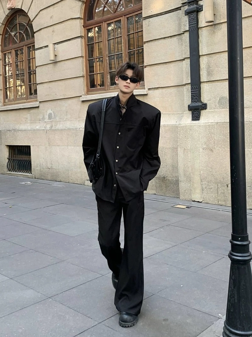 Black sculpted stand collar oversized streetwear shirt styled with black trousers in an urban walking outfit