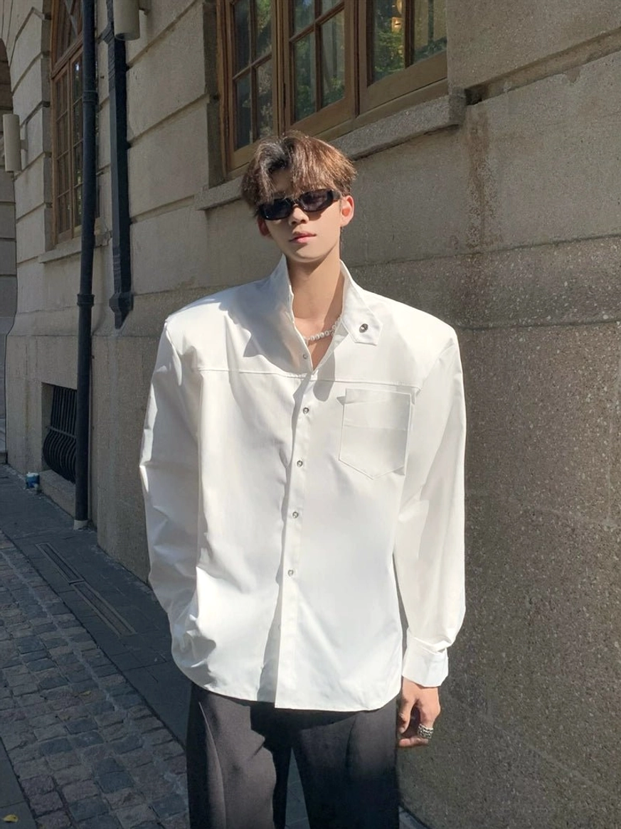 White sculpted stand collar oversized streetwear shirt front full body outfit on an urban stone street