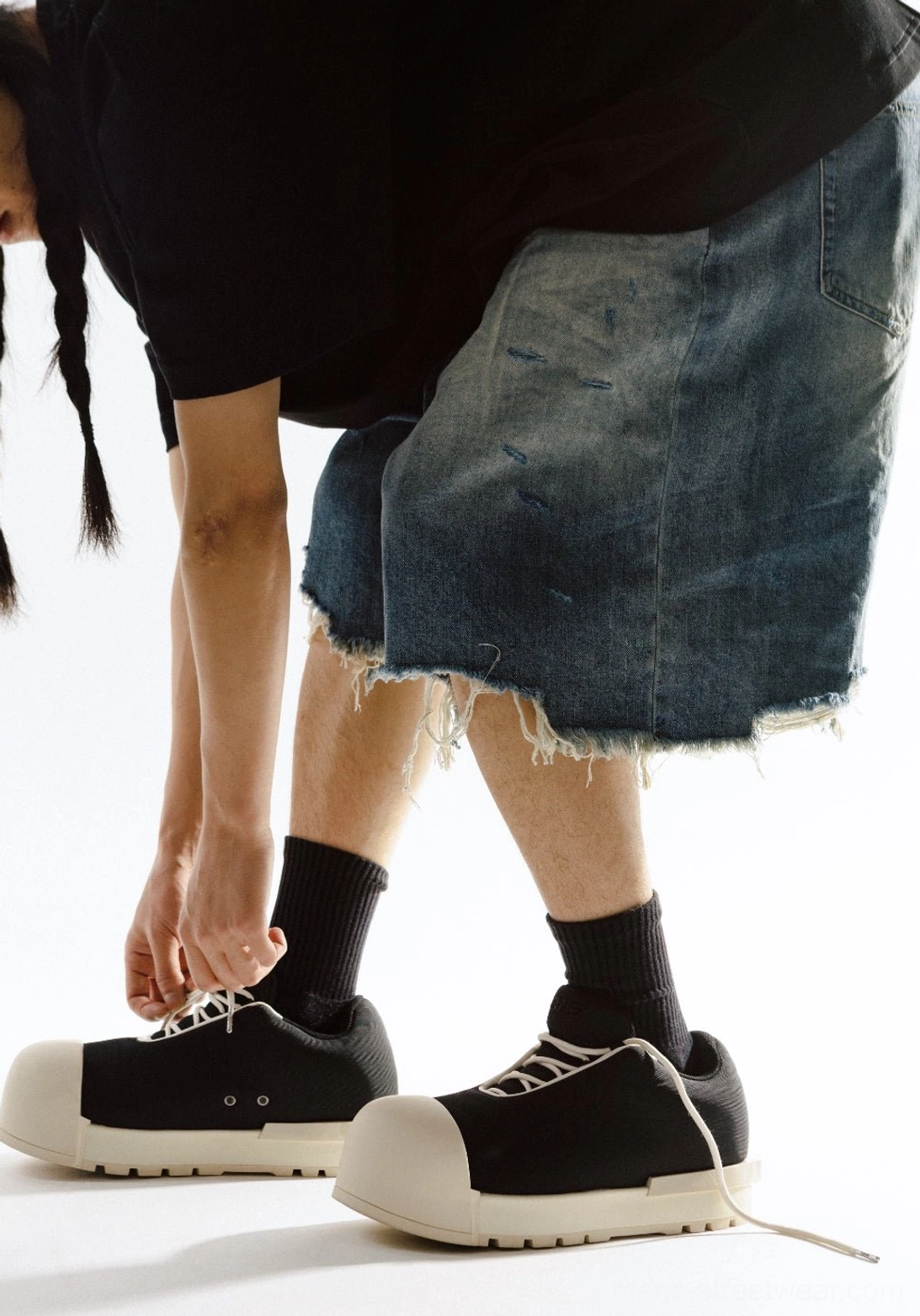 Close side view of black lace-up platform boots showing the sculpted toe and textured anti-slip outsole