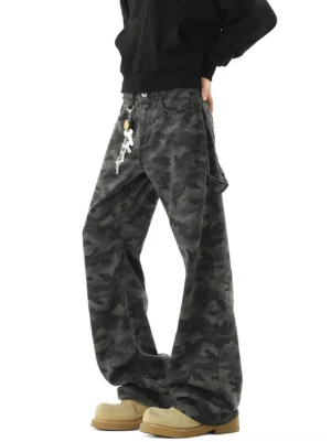 Men's shadow camouflage ultra-wide cargo street jeans front three-quarter view with dark grey camo print, low-slung waist, metal waist pendant and tan work boots