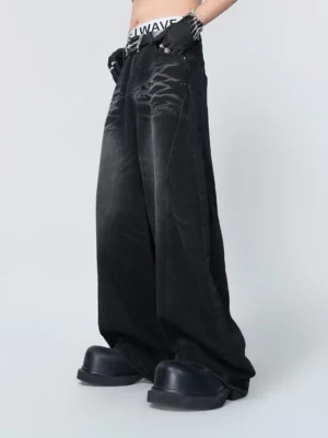 Front left oblique view of wide-leg black washed denim jeans with faded echo-flame detailing, oversized streetwear silhouette, and long draped legs