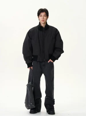 Black cropped bomber jacket three quarter front view styled with wide leg dark denim and tote bag