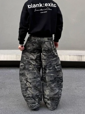 Back view of model wearing dark grey camouflage balloon cargo pants with oversized wide legs, side pockets, waist chain, and black streetwear sweatshirt