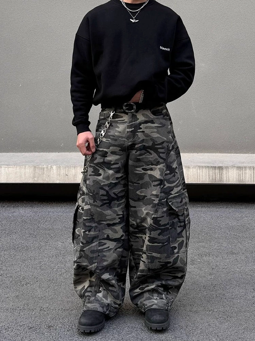 Front view of dark grey camouflage cargo balloon pants with baggy wide leg silhouette, functional pockets, belt chain, and black sweatshirt