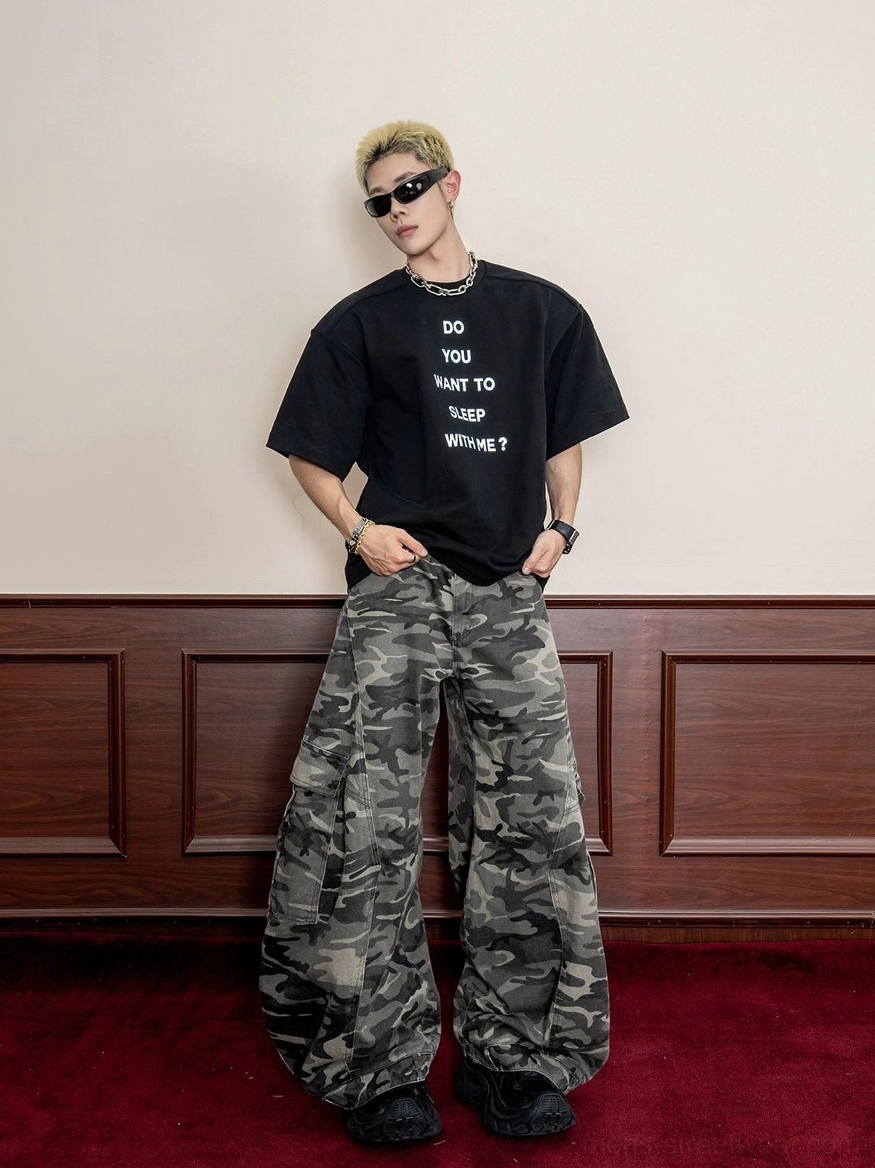 Front full-body view of oversized washed camouflage wide-leg cargo pants styled with a black graphic t-shirt for urban streetwear