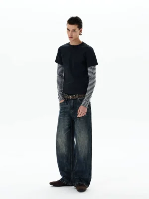 Three-quarter rear view of a faux two-piece striped layered long sleeve tee styled with vintage denim jeans