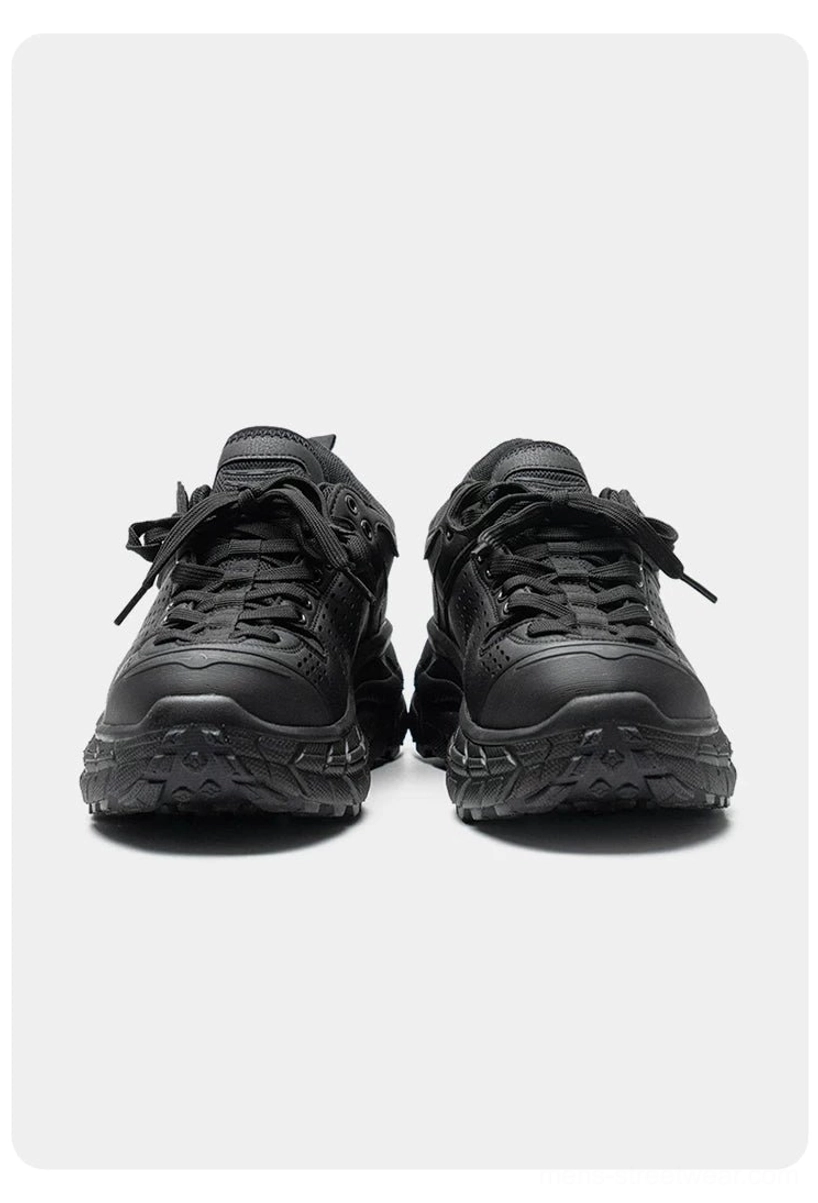Front-facing pair of black heavy-duty casual sneakers with symmetrical laces, matte finish, and deep anti-slip lug outsole