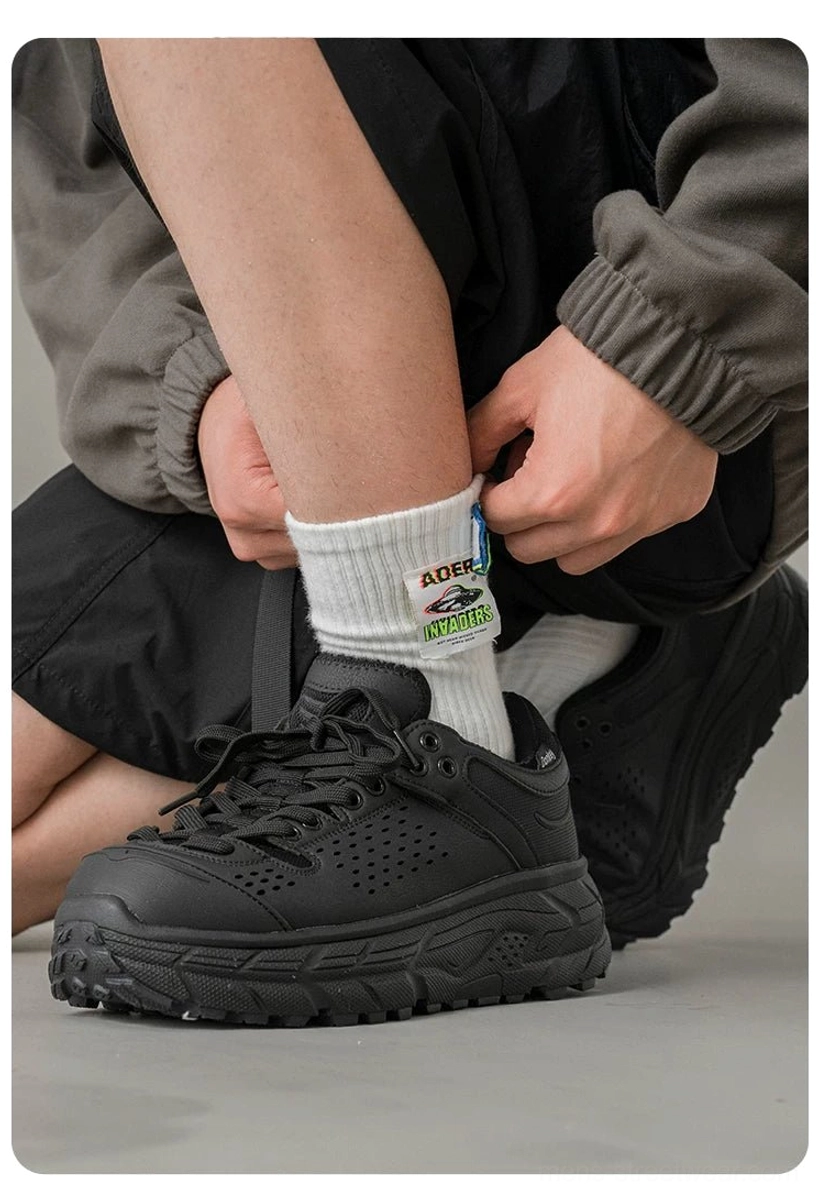 Close-up view of black outdoor training shoes with breathable perforated upper, chunky EVA sole, and classic lace-up fastening