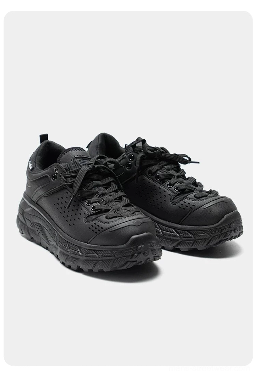 Front flat lay of matte black utility trainers with chunky platform EVA outsole, breathable design, and rear heel pull tab