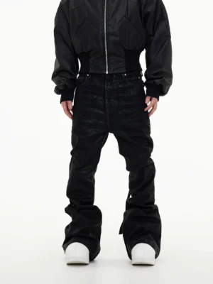 Front view of men's shadow washed black stacked wide-leg jeans with waxed denim finish, ultra-wide flared legs, and white sneakers