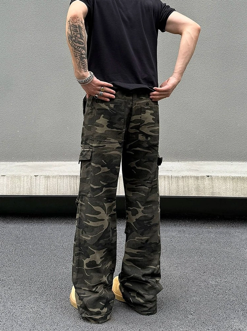 Rear full-body view of dark woodland camouflage wide-leg cargo pants showing back pockets and relaxed streetwear fit
