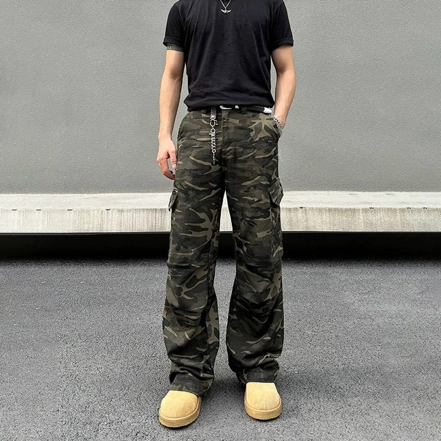 Front full-body view of camouflage wide-leg cargo pants with utility pockets, relaxed fit, and stacked boot hem